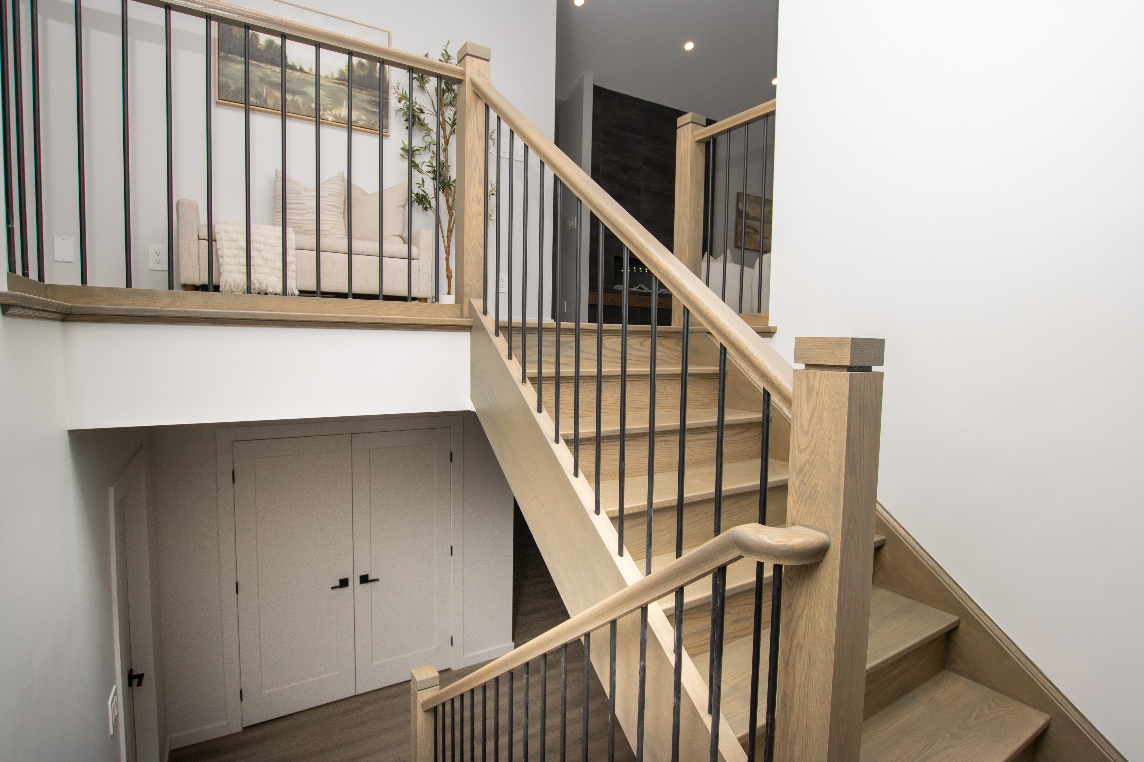 Oak staircase with black metal balusters and under-stair storage