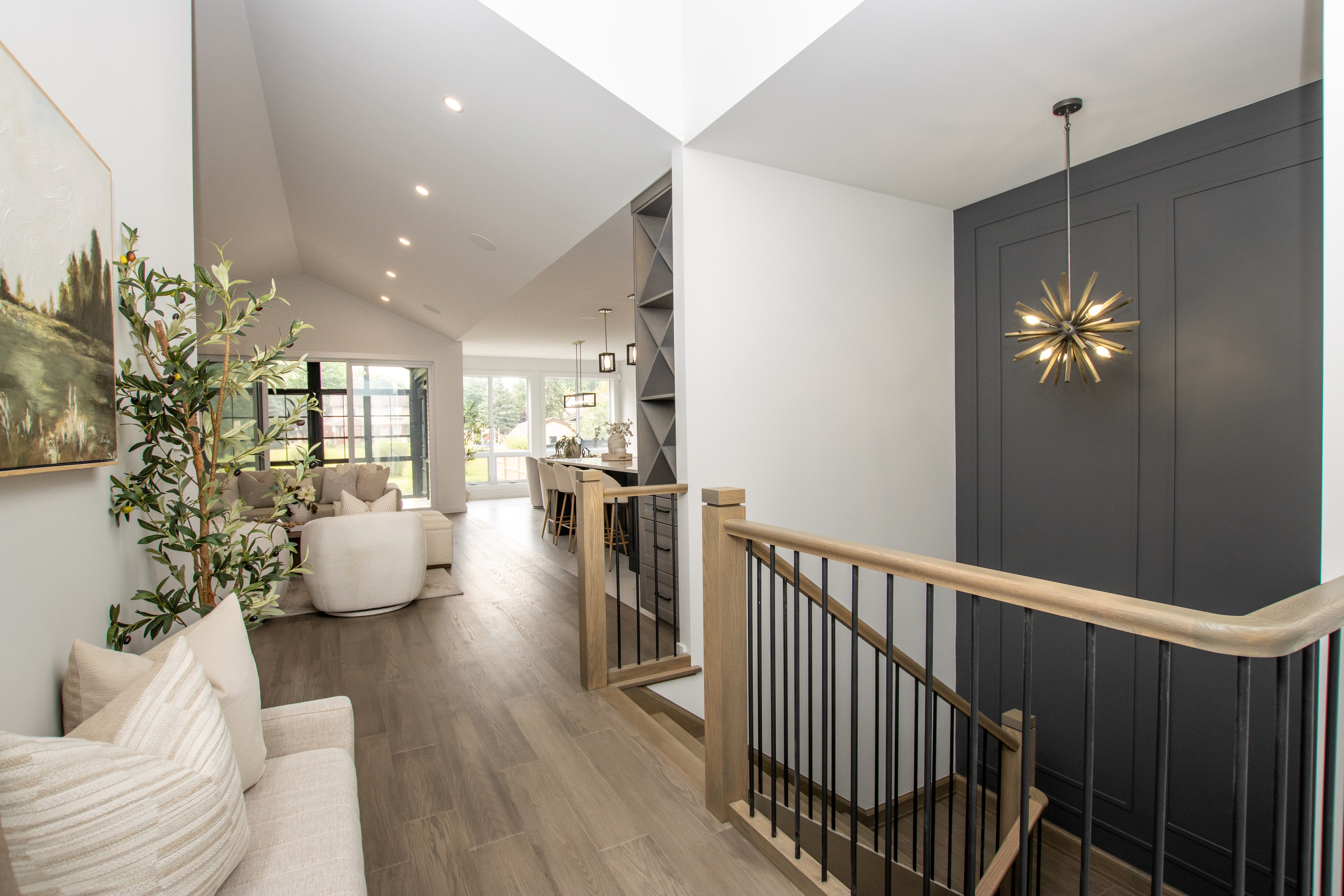 99 Optimist Drive — open-concept living room with staircase and designer lighting