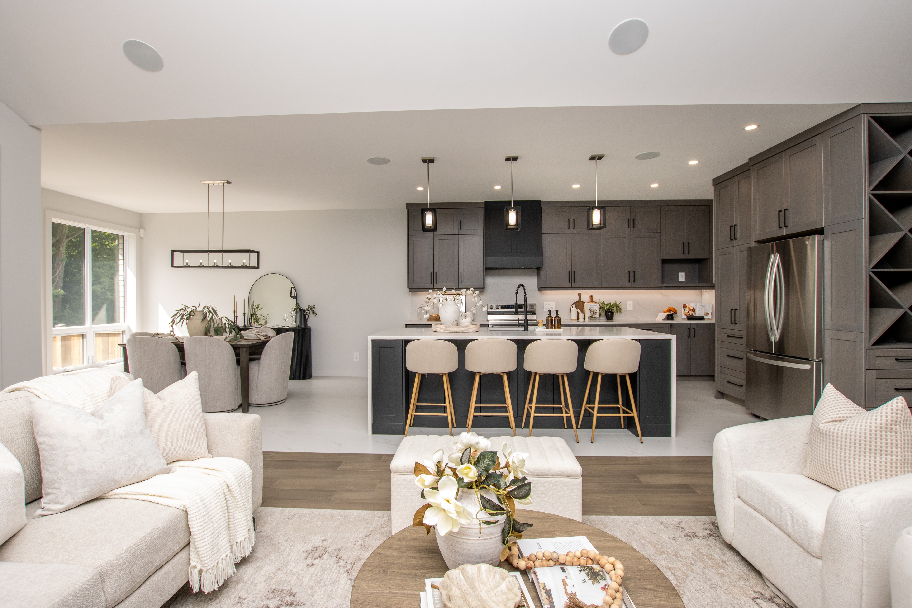 99 Optimist Drive — open-concept kitchen and living area with dark cabinetry and island