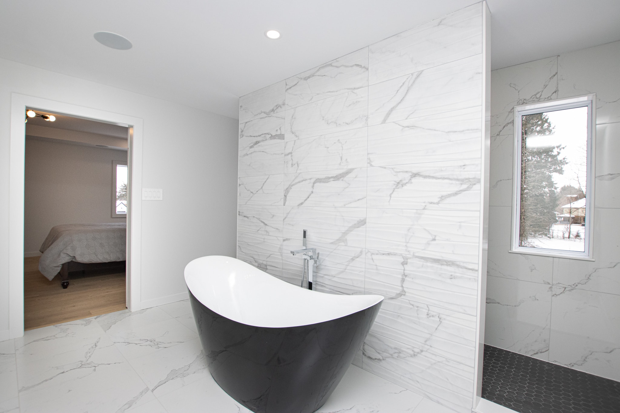 115 Optimist Drive — luxury ensuite with freestanding soaker tub and marble tile